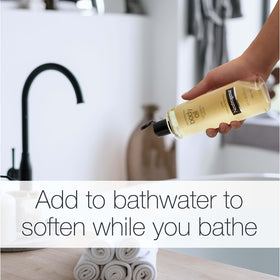 Neutrogena bottle beside bathtub to show adding oil to bath for nourished skin