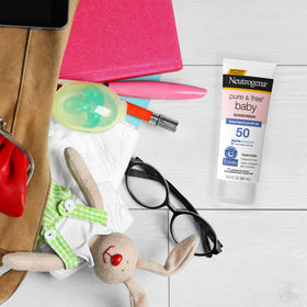 Three Neutrogena Pure & Free Baby tubes packed inside a diaper bag for travel