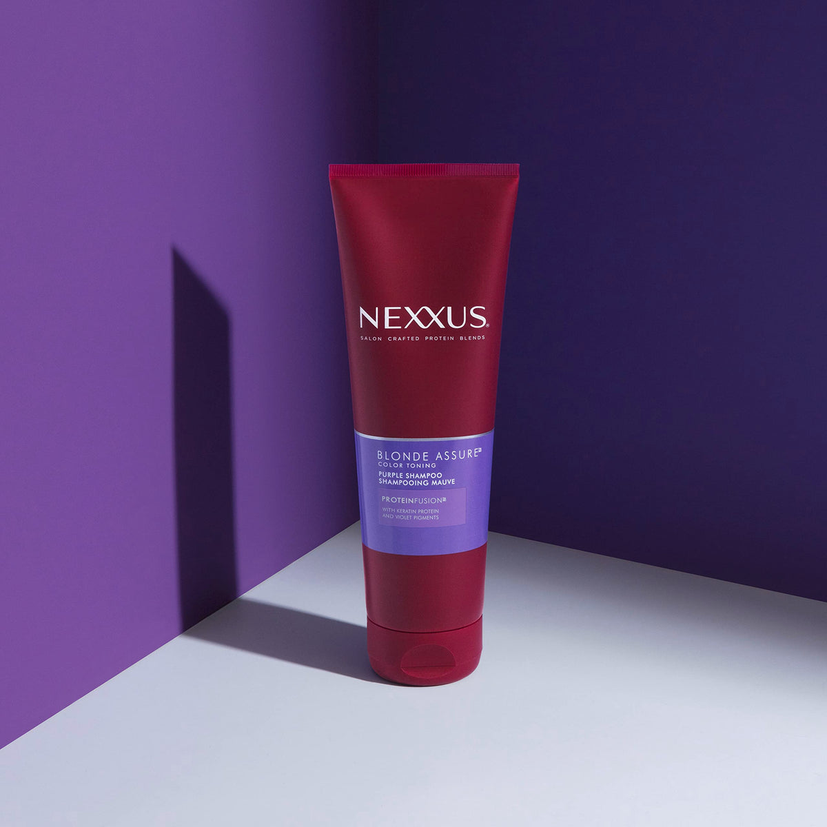 Nexxus shampoo lather being applied to blonde hair for toning benefit