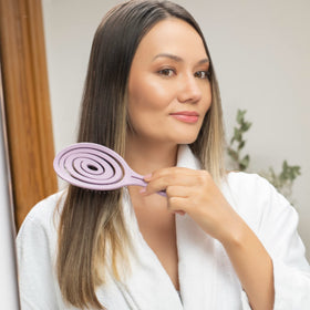 Ninabella brush next to wig on stand to protect extensions and maintain style