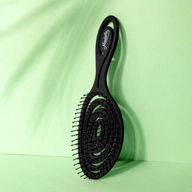 Ninabella brush in use on curly hair reducing knots with minimal tug