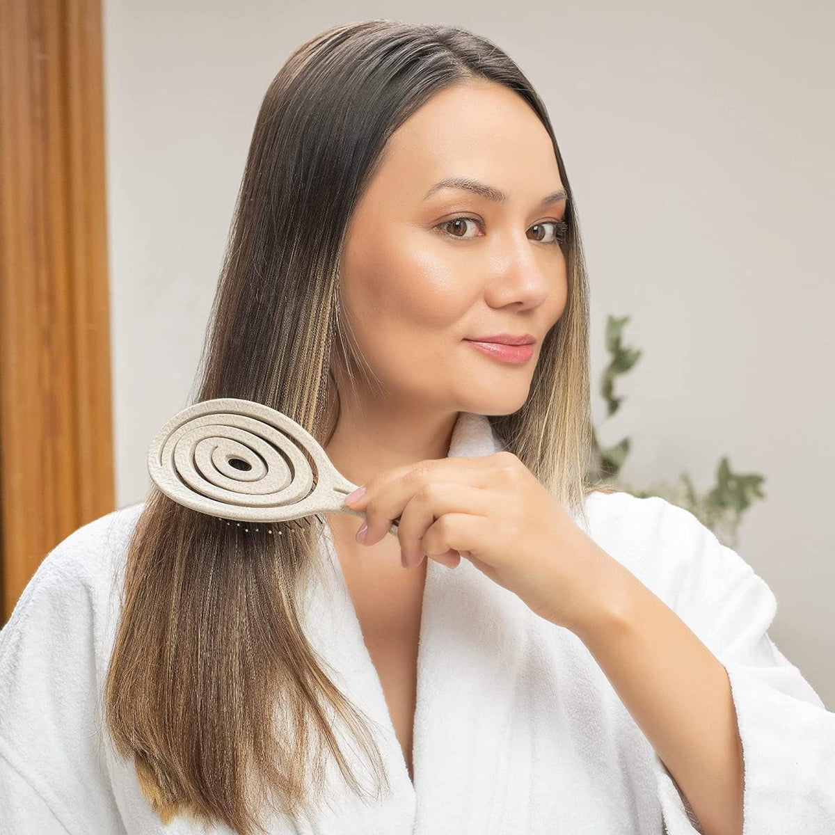 Ninabella brush held in hand for scale showing lightweight travel-friendly size
