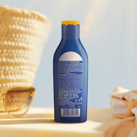 Person applying NIVEA on shoulders at beach for travel convenience