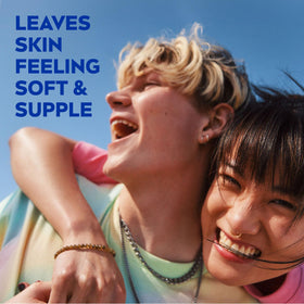 NIVEA Soft tube next to a hand to show 2.6 oz scale and portability benefit