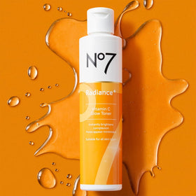 No7 Radiance+ toner applied on model's cheek with cotton pad, demonstrates soothing exfoliation