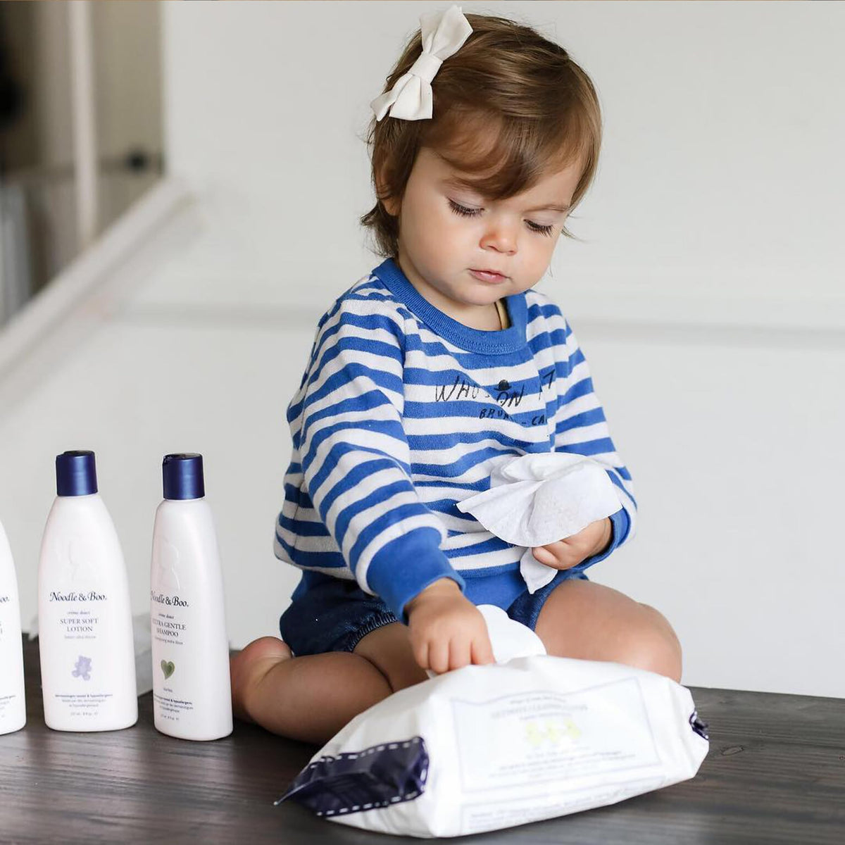 Noodle & Boo wipe held in adult hand for scale, thick durable feel benefit