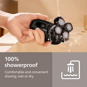 Norelco Pro 5000 held beside hand to show compact size and portability