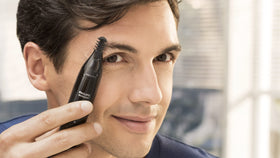 Norelco trimmer beside toiletry bag illustrating travel-ready convenience