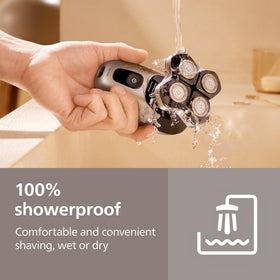 Philips Norelco next to a hand showing compact size and easy maneuverability