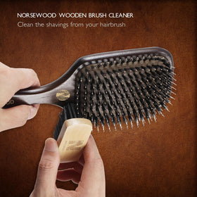 Norsewood brush next to hand showing size and lightweight design