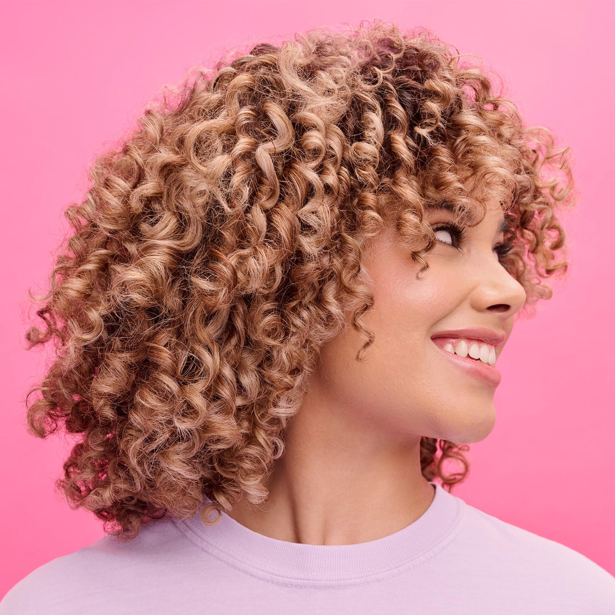 Not Your Mother's lifestyle shot of woman with defined curls showing enhanced curl definition benefit