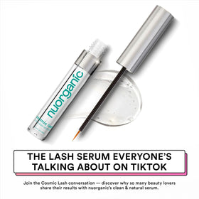 NuOrganic Cosmic Lash serum drop on fingertip showing lightweight texture and quick absorption
