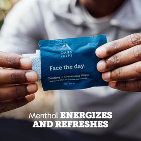 Oars + Alps wipe in hand used on face showing convenient post-workout freshening benefit