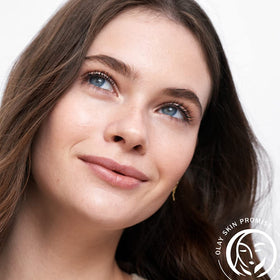Lifestyle image of woman applying Olay toner with cotton pad for fresh skin