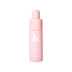Olive & June Dry Drops front packaging showing compact travel-ready tube and label benefits