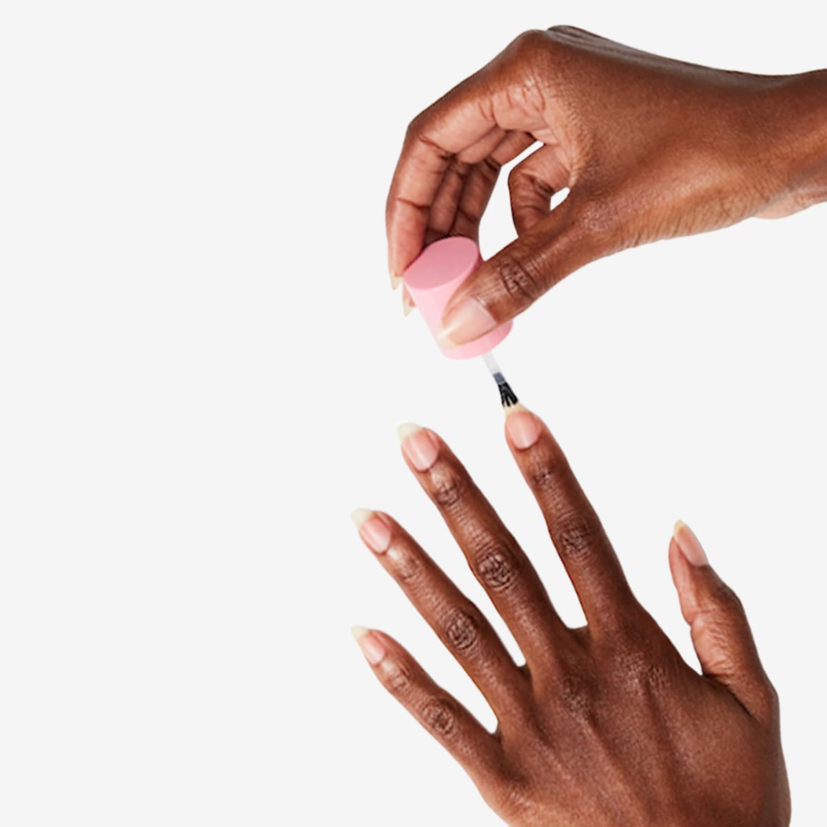 Olive & June applying strengthener to a natural nail for conditioning
