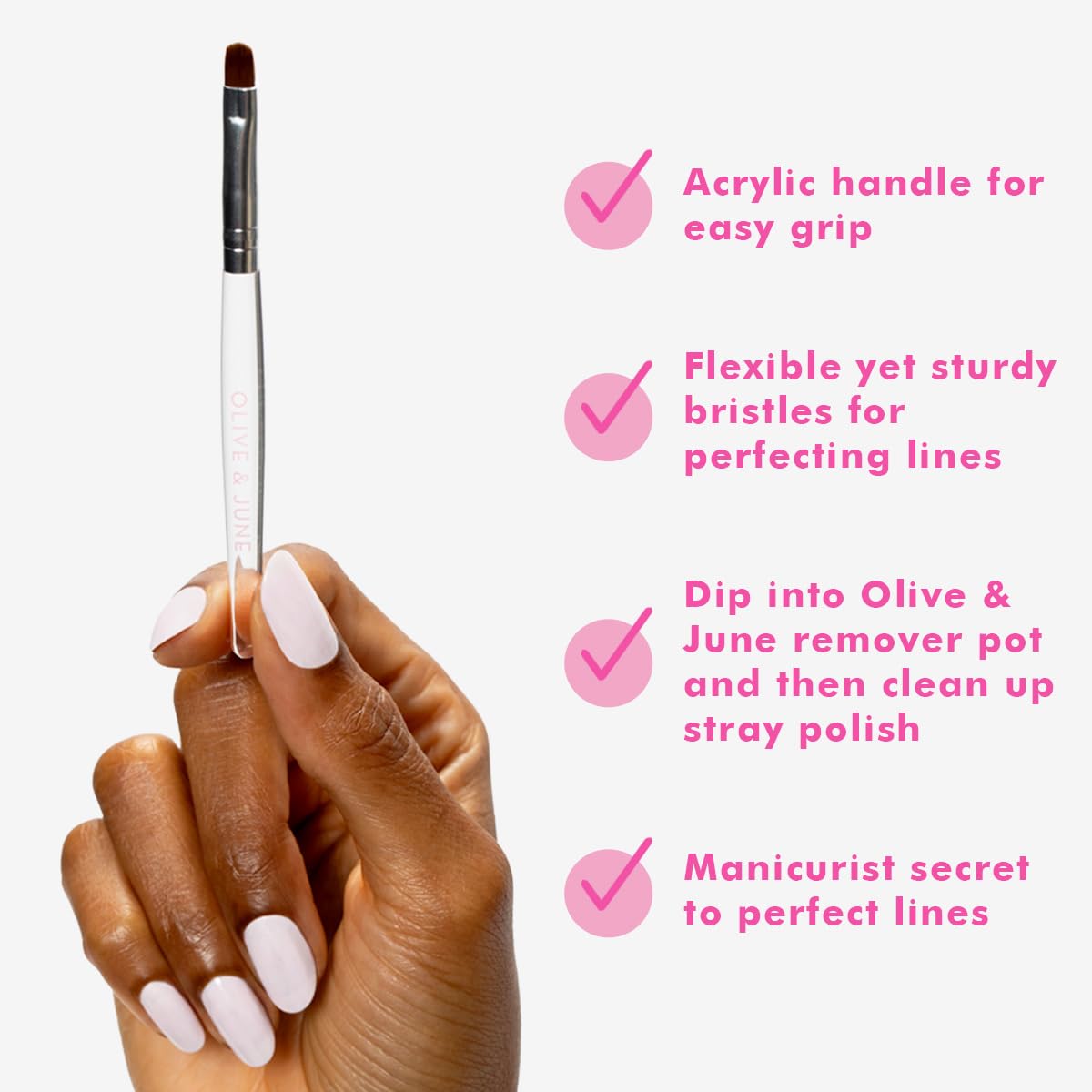 Olive & June brush in use removing stray polish for clean manicure edges