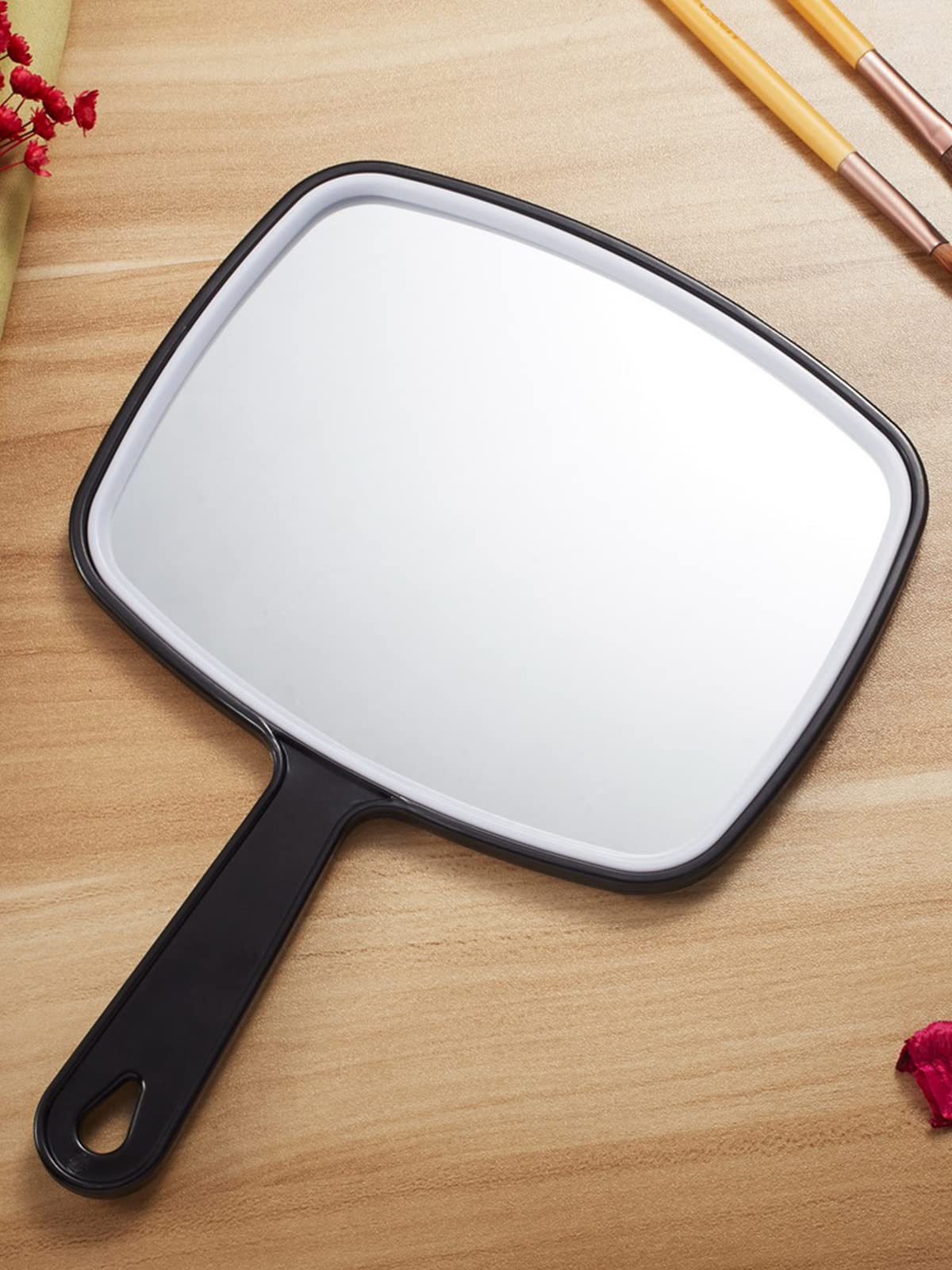 OMIRO hand mirror hanging on hook showing space-saving storage benefit tidy bathroom