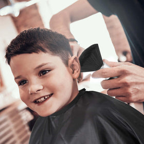 Omvoina cape in use during haircut showing protection and tidy workspace benefit