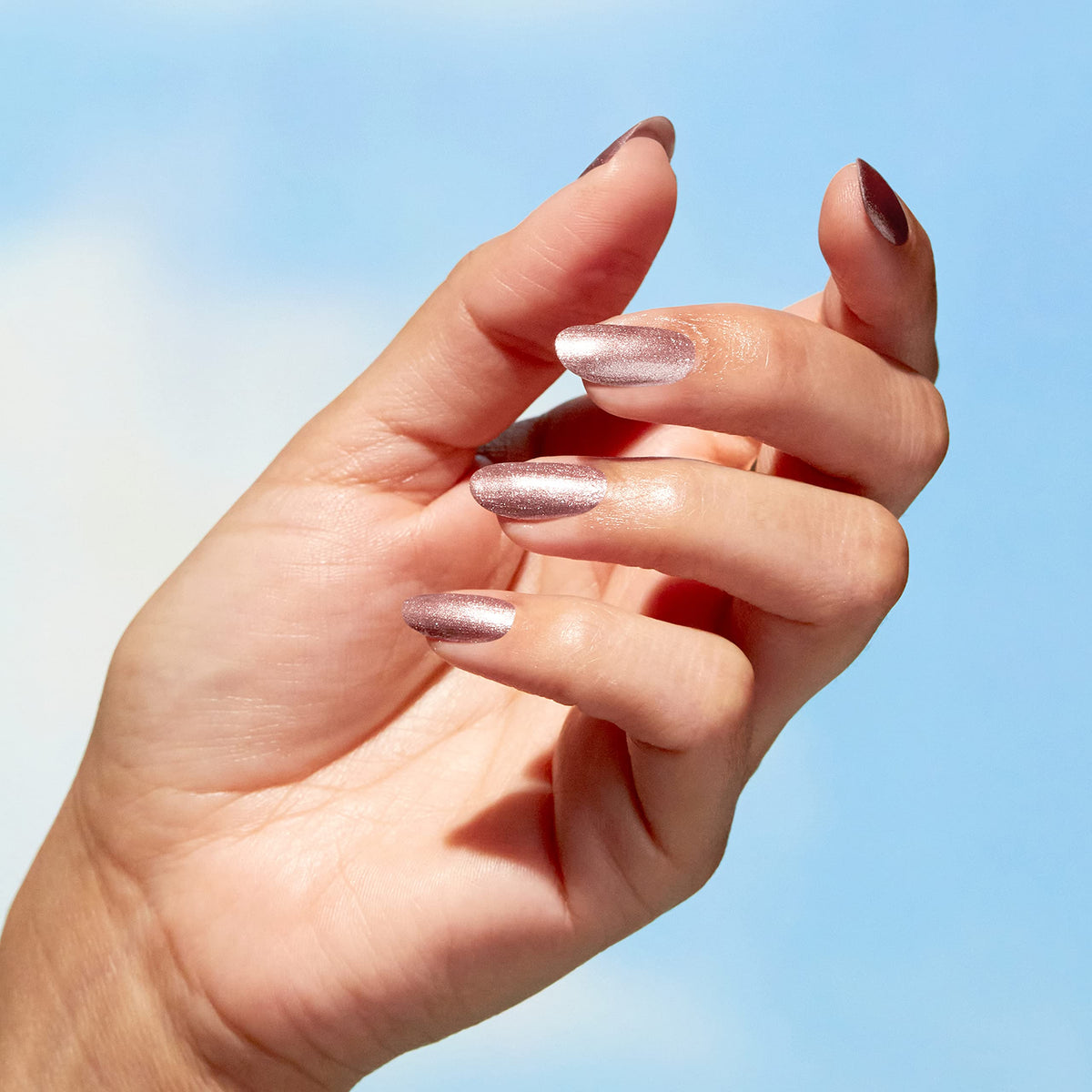 Hand model wearing OPI rose gold polish showing wearable neutral finish