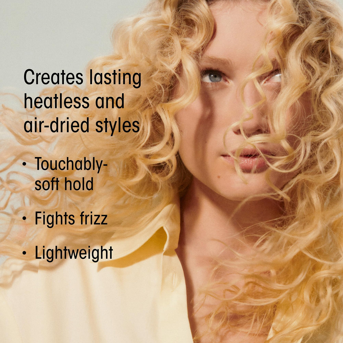 Oribe product applied to damp hair in hands for frizz control benefit