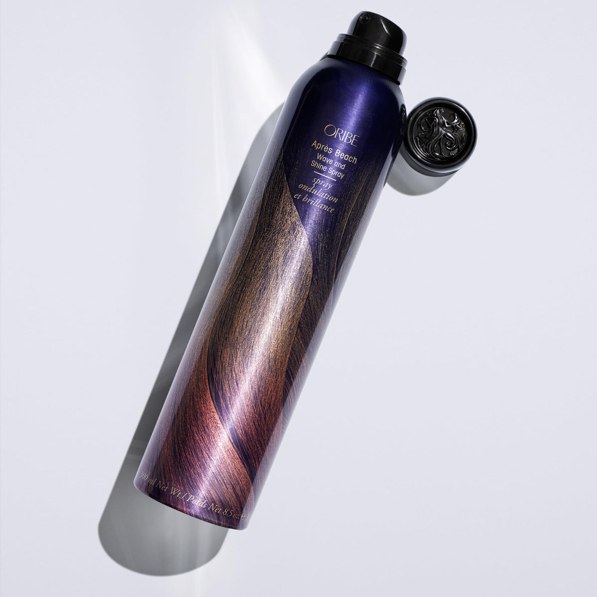 Oribe Après Beach 8.5oz beside a ruler to show bottle size and travel-friendly benefit