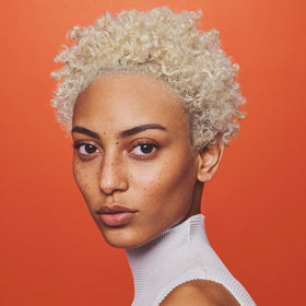 Oribe Bright Blonde used by stylist in salon, conveys professional-level gentle enhancement
