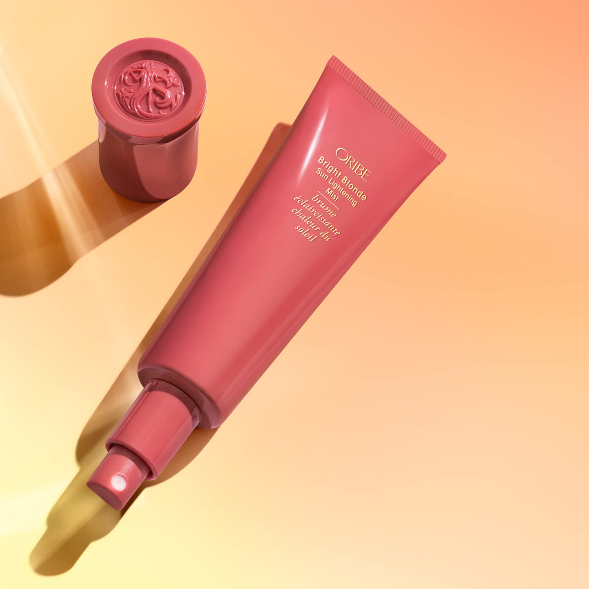 Oribe Bright Blonde mist visible on hair strands, illustrates lightweight hydration and luminosity