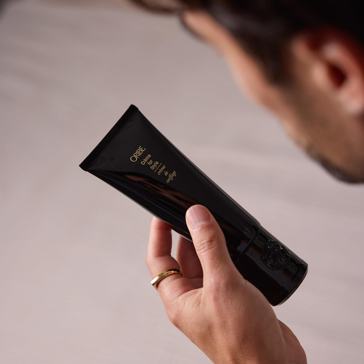 ORIBE tube staged with styling tools suggesting professional results
