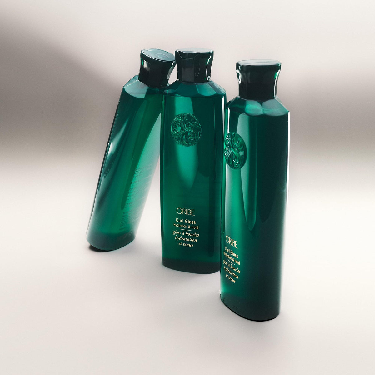 Oribe Curl Gloss applied to curly hair demonstrating defined, glossy curls