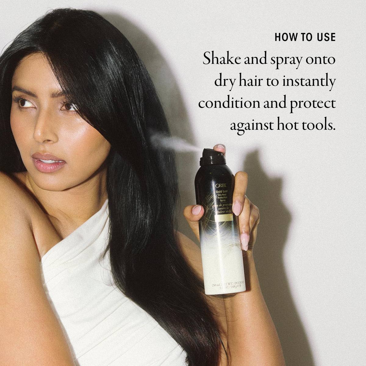 Stylist applying Oribe Gold Lust to dry hair to protect before hot tools