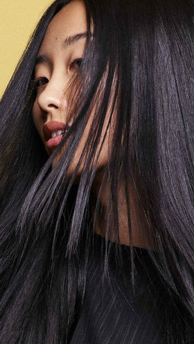 Oribe in-shower use showing product being applied to wet hair for hydration benefit