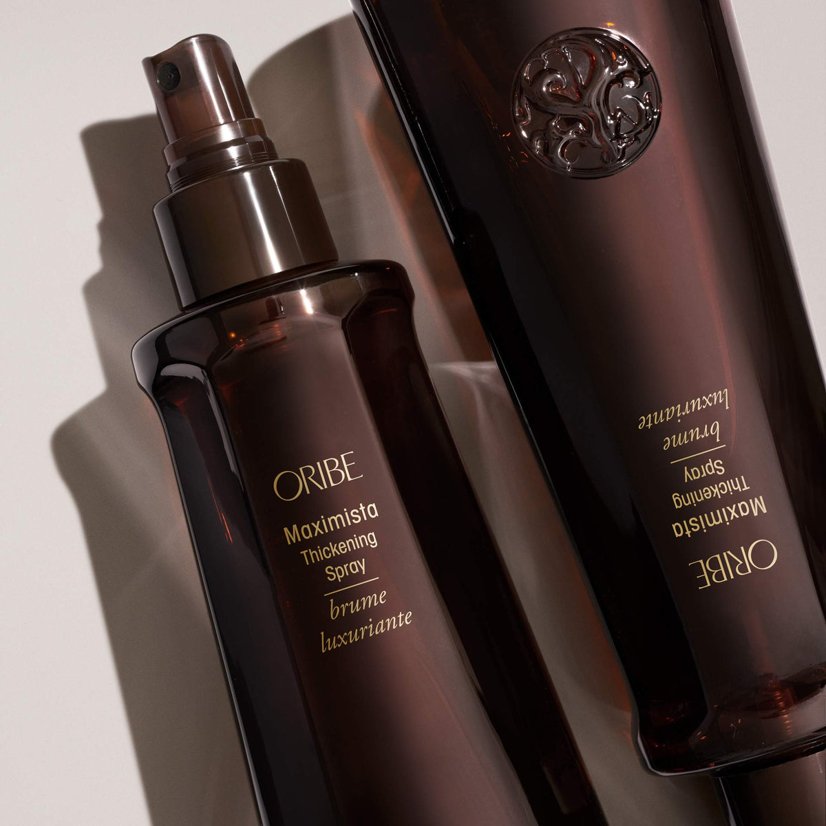 Hand holding Oribe Maximista bottle showing scale and travel-ready convenience