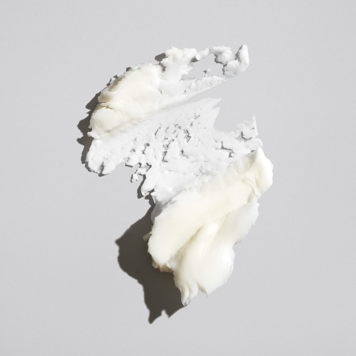Oribe paste texture close-up on fingertip, brand gives easy spreadability