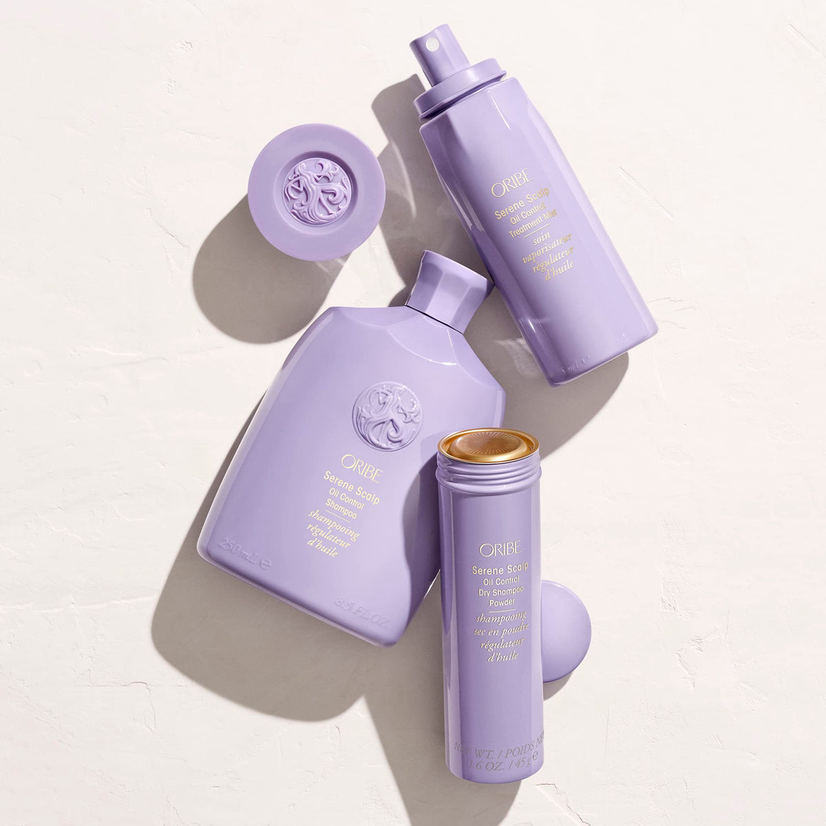 oribe bottle beside everyday items for scale and travel-friendly benefit