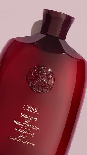 Oribe bottle held in hand demonstrating 8.5 oz size and travel-friendly benefit