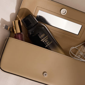 Stylist applying Oribe Impermeable to a blowout to lock out frizz
