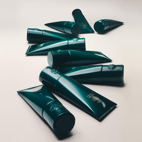 Oribe applying cream to coily hair to show curl definition and frizz control