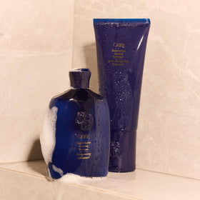 Oribe Supershine lifestyle bathroom scene conveying luxe routine and polished finish