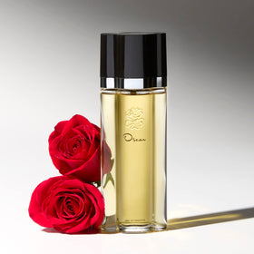 Oscar de la Renta bottle on a vanity with flowers suggesting everyday elegance