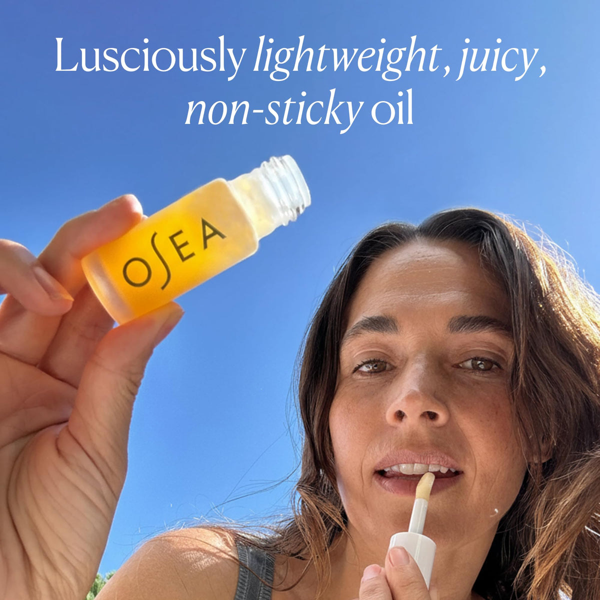 OSEA lip oil layered over lipstick showing enhanced shine benefit versatile finish