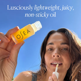 OSEA lip oil layered over lipstick showing enhanced shine benefit versatile finish