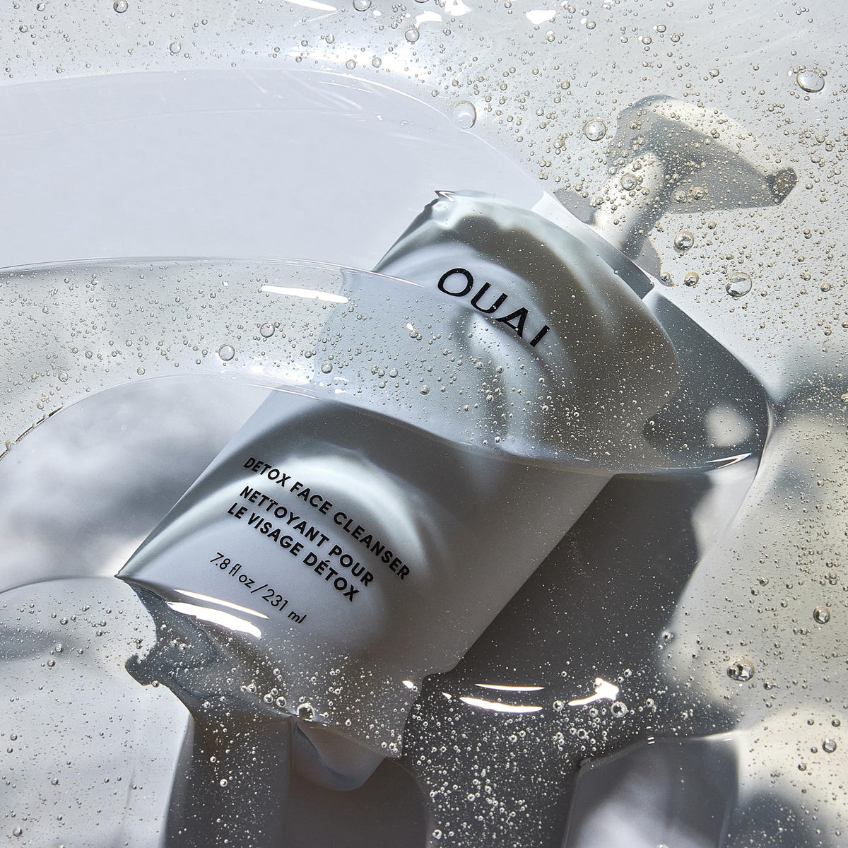 OUAI pouring cleanser into hand demonstrating creamy application and easy rinse