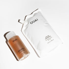 OUAI 32 oz refill next to hand showing large sustainable size
