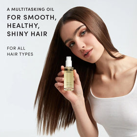 OUAI hair oil drop dispensing close-up demonstrating controlled application benefit