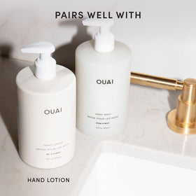 OUAI bottle next to a hand for scale showing 16 fl oz size advantage