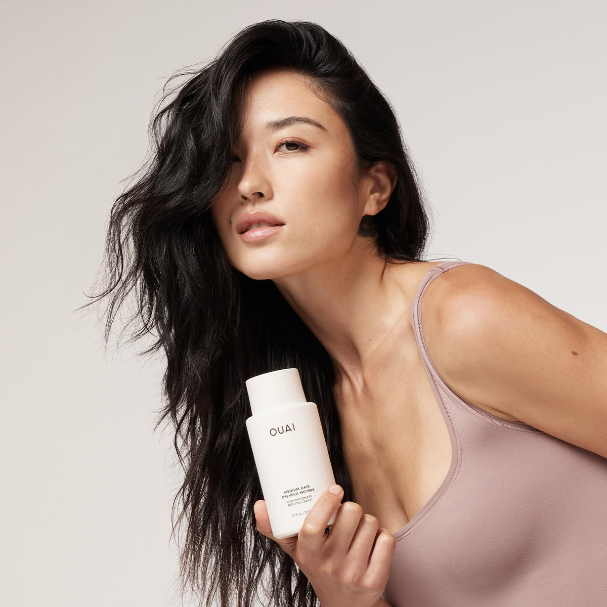 OUAI medium conditioner texture pouring from pouch showing creamy hydrating consistency