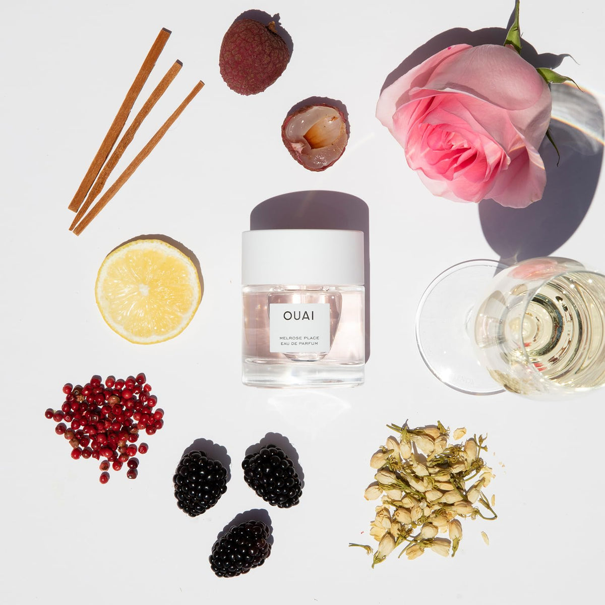 OUAI perfume being misted on wrist showing application and long-lasting benefit
