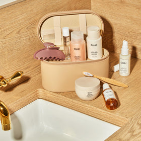 OUAI 3 oz bottle beside passport demonstrating travel-friendly portability