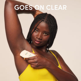 OUAI stick beside a hand for scale showing portable 2.5 oz convenience benefit
